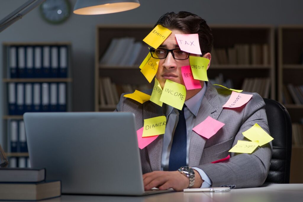 symbolische und überspitzte Darstellung eines Mannes mit adhs im Büro, der durch seine To Do's überfordert ist. Post it's kleben an seinem ganzen Körper.